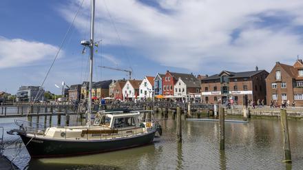 Ausflügler genießen die Außengastronomie und strahlenden Sonnenschein am Husumer Hafen. 