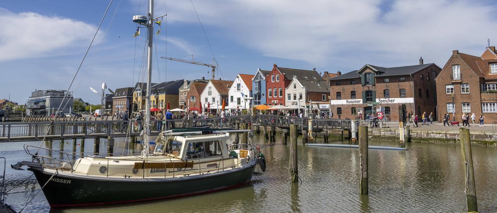 Ausflügler genießen die Außengastronomie und strahlenden Sonnenschein am Husumer Hafen.