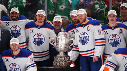Leon Draisaitl posiert hinter Kapitän Connor McDavid mit dem Pokal für den Sieger der Western Conference.