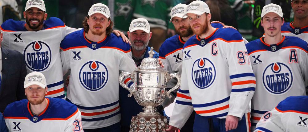 Leon Draisaitl posiert hinter Kapitän Connor McDavid mit dem Pokal für den Sieger der Western Conference.