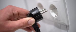 Ein Stecker wird in eine Steckdose gesteckt.