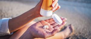 Eine Frau drückt Sonnencreme aus der Tube.