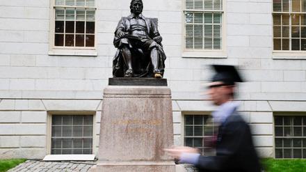 Ein Student geht auf dem Campus der Harvard Universität an der Statue von John Harvard vorbei.