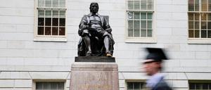 Ein Student geht auf dem Campus der Harvard Universität an der Statue von John Harvard vorbei.
