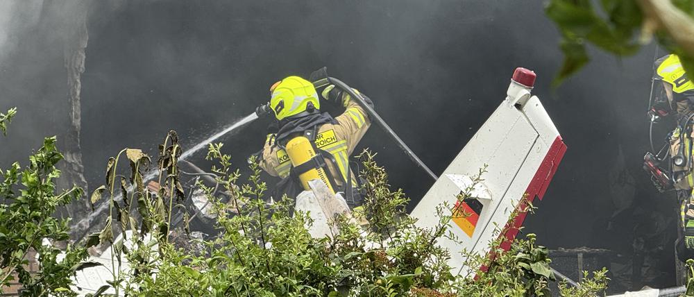 Die Feuerwehr arbeitet an der Absturzstelle, nachdem ein Flugzeug in ein Wohnhaus gestürzt ist.