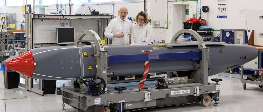 31.05.2025, Großbritannien, Stevenage: Louise Holmes, stellvertretende Geschäftsführerin von MBDA UK, zeigt dem britischen Verteidigungsminister John Healey (l) einen Storm Shadow-Flugkörper auf einem Fließband in einer Fabrik.