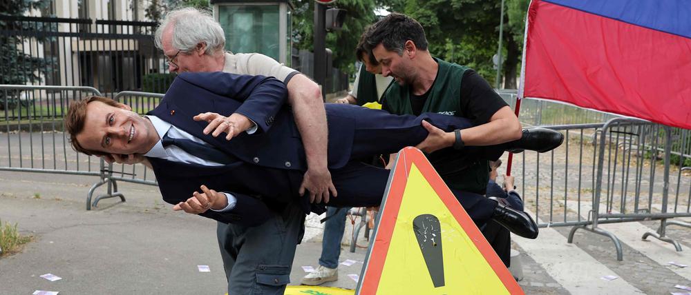 Greenpeace-Umweltschützer stellen während einer Aktion gegen Frankreichs Gas- und Düngemittelimporte aus Russland vor der russischen Botschaft in Paris am 2. Juni 2025 eine Wachsfigur des französischen Präsidenten Emmanuel Macron auf.