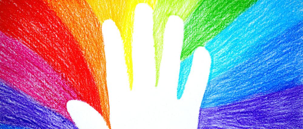 Abdruck einer Kinderhand in einer Regenbogenzeichnung.
