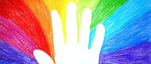 Abdruck einer Kinderhand in einer Regenbogenzeichnung.