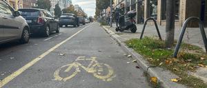 Der Radweg in der Kantstraße in dem Berliner Stadtteil Charlottenburg führt zwischen parkenden Autos und dem Fußgängerweg entlang.