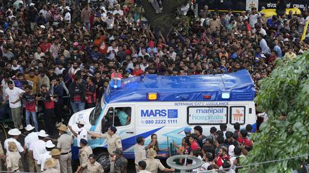 Ein Krankenwagen bahnt sich den Weg durch eine Menschenmenge am M. Chinnaswamy-Stadion in der indischen Stadt Bengaluru. 