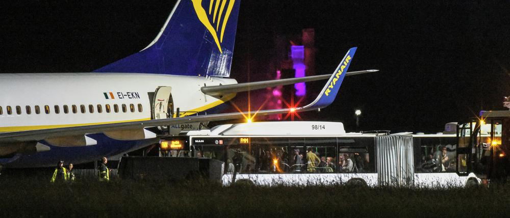 Ein Bus mit Reisenden steht vor einem Passagierjet der Fluggesellschaft Ryanair auf dem Vorfeld am Flughafen Memmingen. Der Flieger war von Berlin nach Mailand unterwegs, als er in Turbulenzen geratenen ist.