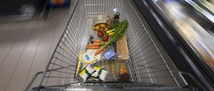 Ein Einkaufswagen mit Lebensmitteln steht in einem Supermarkt.