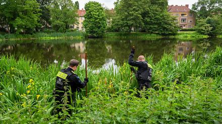 Nach einem Raubmord in Berlin-Reinickendorf sucht die Polizei einen Teich und dessen Umgebung ab.