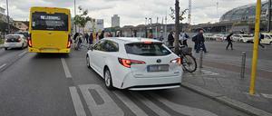 Fahrgäste müssen auf der Fahrbahn aussteigen, weil ein Mietwagen die Haltestelle blockiert. 