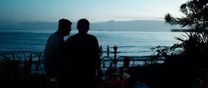 Paar im Schatten vor schöner Meereskulisse.