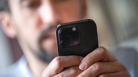 Ein Mann hält ein Handy in der Hand. 