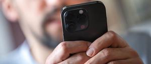 Ein Mann hält ein Handy in der Hand. 