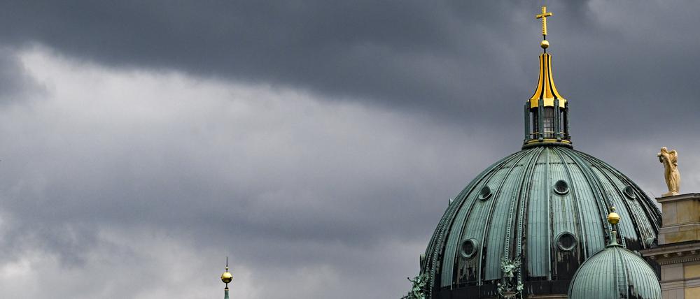 Berlin: Dunkle Wolken sind am Himmel hinter dem Dom zu sehen. (Archivbild)