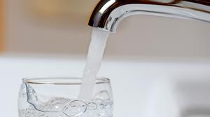 Wasser läuft aus einem Wasserhahn in ein Wasserglas (Symbolfoto).