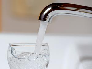 Wasser läuft aus einem Wasserhahn in ein Wasserglas (Symbolfoto).