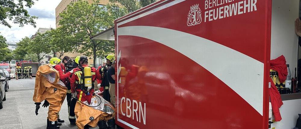 Einsatzkräfte der Berliner Feuerwehr legen Schutzausrüstung an.