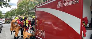 Einsatzkräfte der Berliner Feuerwehr legen Schutzausrüstung an.