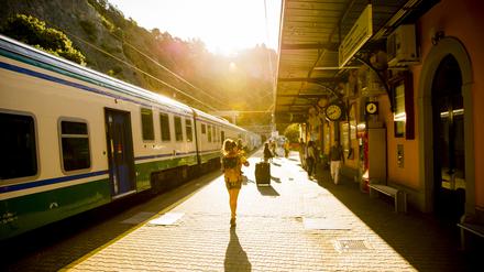 Eine Frau läuft zu ihrem Zug auf einem Bahnsteig in Italien. (Symbolbild)
