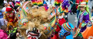 Kinder in traditionellen Kostümen tanzen am Mariannenplatz zur Musik.