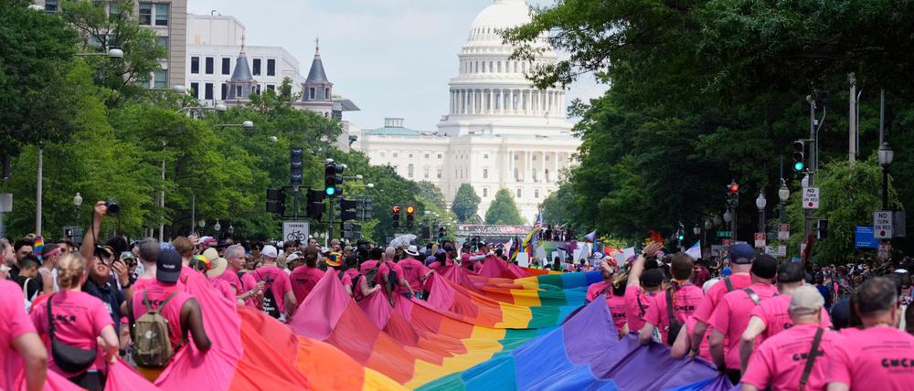 Mit riesigen Regenbogenfahnen demonstrieren Menschen mit Blick auf das US-Kapitol bei einer Pride-Parade in Washington für die Rechte der LGBTQI+-Gemeinschaft. 