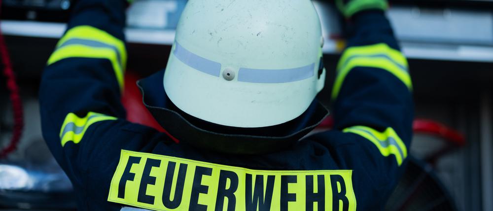 Ein Feuerwehrmann holt Equipment aus einem Einsatzfahrzeug. (Symbolbild)