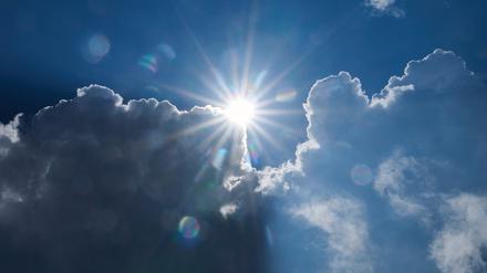 Die Sonne scheint am Rand von dunklen Wolken.