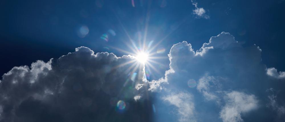 Die Sonne scheint am Rand von dunklen Wolken.