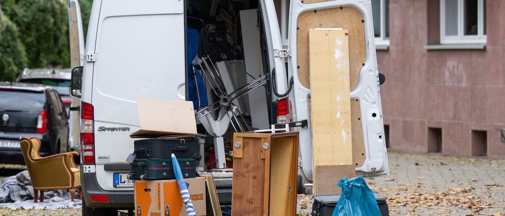 Möbel und Umzugskartons stehen vor einem Transporter an einem Wohnhaus in Leipzig (Symbolbild).
