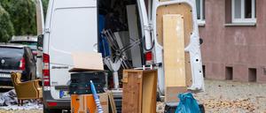 Möbel und Umzugskartons stehen vor einem Transporter an einem Wohnhaus in Leipzig (Symbolbild).