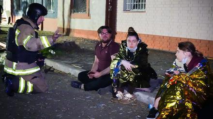 Auf diesem vom ukrainischen Rettungsdienst am 10. Juni 2025 veröffentlichten Handout-Foto spricht ein ukrainischer Retter mit Anwohnern am Ort eines Drohnenangriffs in Odessa.