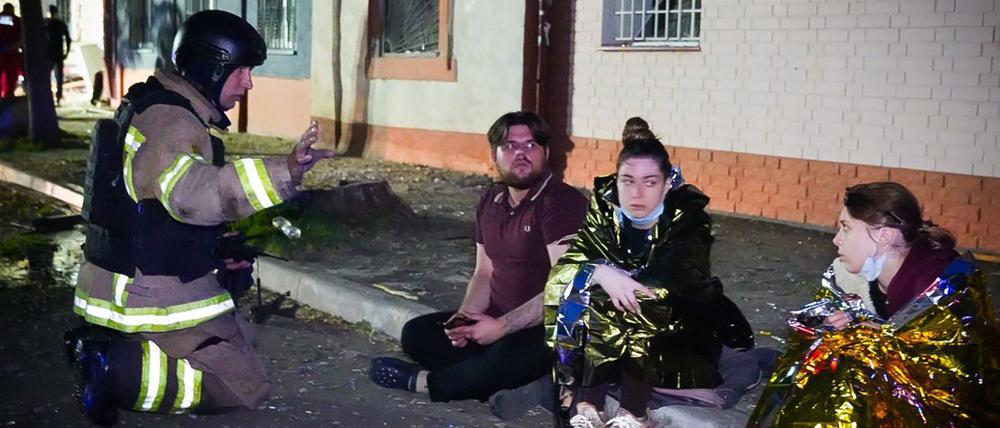 Auf diesem vom ukrainischen Rettungsdienst am 10. Juni 2025 veröffentlichten Handout-Foto spricht ein ukrainischer Retter mit Anwohnern am Ort eines Drohnenangriffs in Odessa.