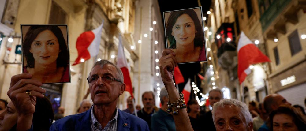 People hold up photos of late anti-corruption journalist Daphne Caruana Galizia during a protest march on the sixth anniversary of her assassination.