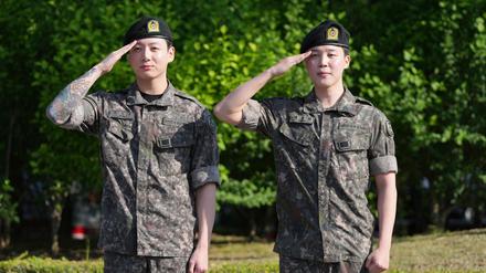 Die Mitglieder der K-Pop-Band BTS, Jimin (r) und Jung Kook, salutieren nach ihrer Entlassung aus dem Militärdienst.