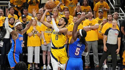 Indiana Pacers Star Tyrese Haliburton (0) beim Wurf gegen MVP Shai Gilgeous-Alexander (2) und Luguentz Dort (5).