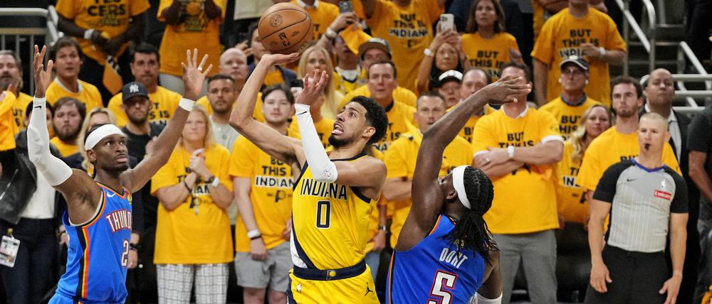 Indiana Pacers Star Tyrese Haliburton (0) beim Wurf gegen MVP Shai Gilgeous-Alexander (2) und Luguentz Dort (5).