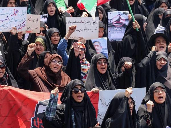 People gather for a protest against Israel's wave of strikes on Iran in central Tehran on June 13, 2025. Israel hit about 100 targets in Iran on June 13, including nuclear facilities and military command centres and killing senior figures including the armed forces chief and top nuclear scientists. (Photo by ATTA KENARE / AFP)