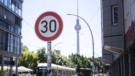 Ein Tempo-30-Schild steht im Vordergrund des Fernsehturms in Berlin.