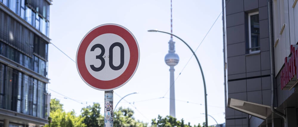 Ein Tempo-30-Schild steht im Vordergrund des Fernsehturms in Berlin.