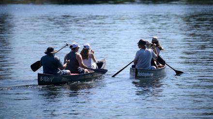 Ausflügler fahren mit Kanus auf der Spree. 