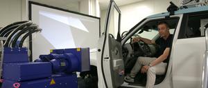 Professor Steffen Müller sitzt im Fahrzeug auf dem „Vehicle-in-the-Loop“-Prüfstand der TU Berlin im Wedding.