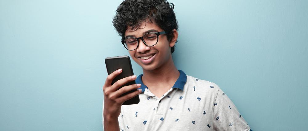 Ein Minderjähriger schaut auf sein Smartphone.