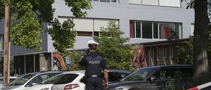 Ein Polizeibeamter telefoniert vor dem Schulgebäude (Symbolbild).