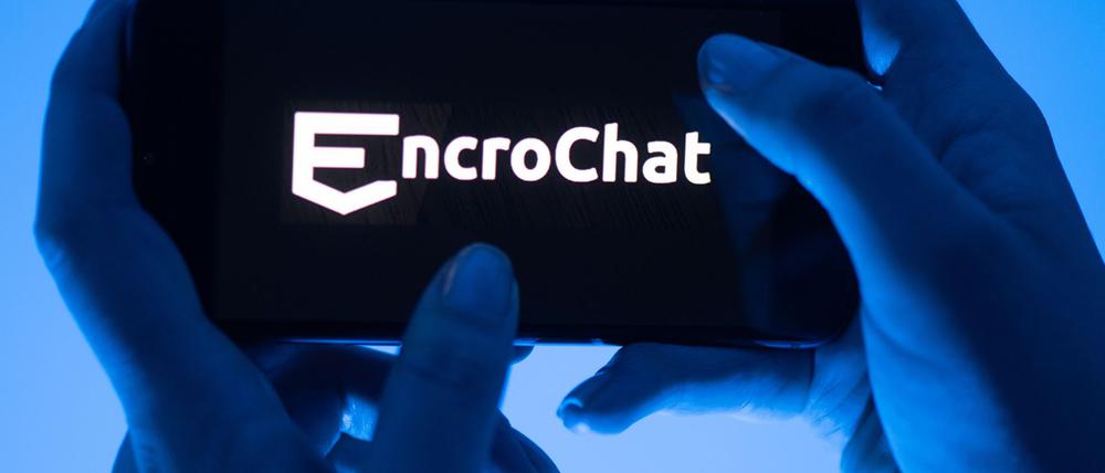 Eine Frau hält ein Smartphone mit dem Logo des Krypto-Messengerdienstes Encrochat. (Symbolbild) 