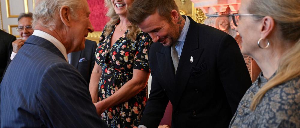 Der britische König Charles III (l) und David Beckham kennen sich seit Jahren persönlich.